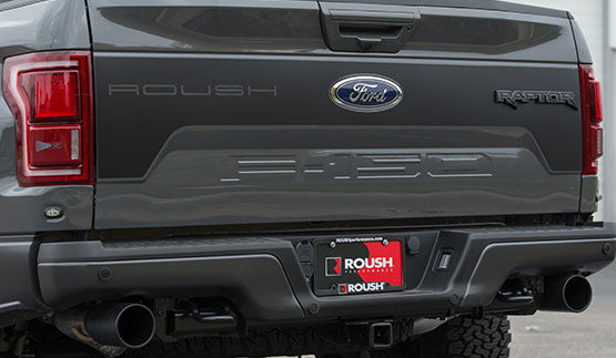 Rear view of a gray ROUSH Raptor F-150 showcasing "ROUSH" branding, dual exhaust, and a Roush license plate frame, equipped with Off-Road Suspension for enhanced adventure capabilities.