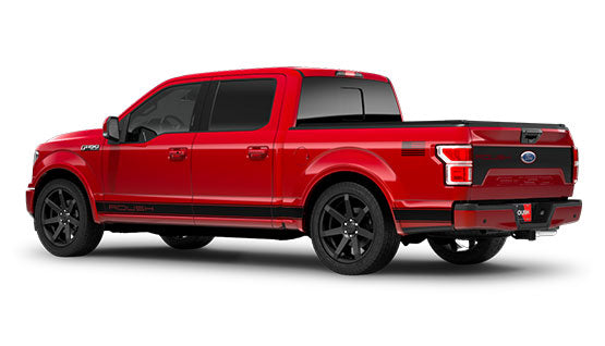 A red ROUSH F-150 Sport pickup truck with a crew cab, black wheels, and visible ROUSH Performance branding on the tailgate and sides is shown from a rear side angle.