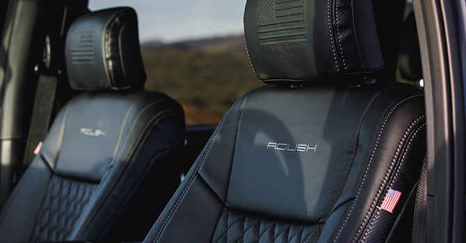 Close-up of black leather truck seats with "ACLISH" embroidered on the headrests, an American flag patch on the side, and a nod to 5.11 Tactical gear. Perfect for a ROUSH F-150, these seats embody rugged elegance and high-performance style.