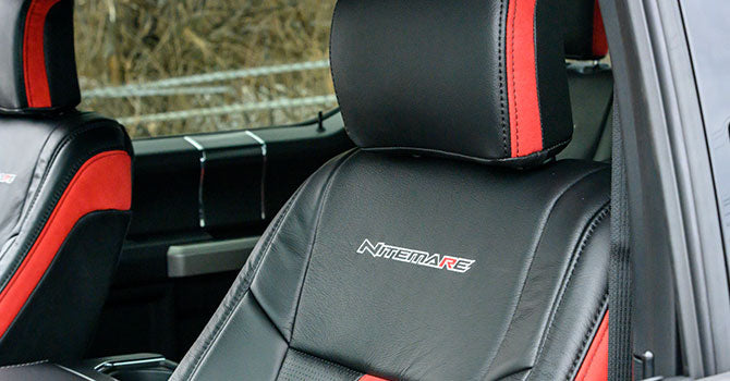Close-up of a black car seat with red accents and "ROUSH Nitemare" embroidered on the backrest, reflecting the power of its supercharged 650-horsepower V8.