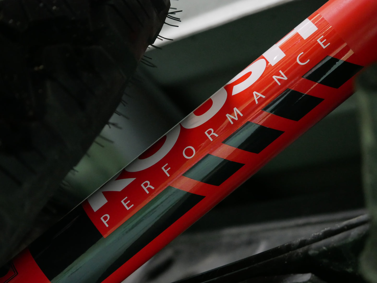 Close-up of a red shock absorber from the Roush Performance Suspension, with "PERFORMANCE" partially obscured by a tire above, showcasing rugged off-road capability.