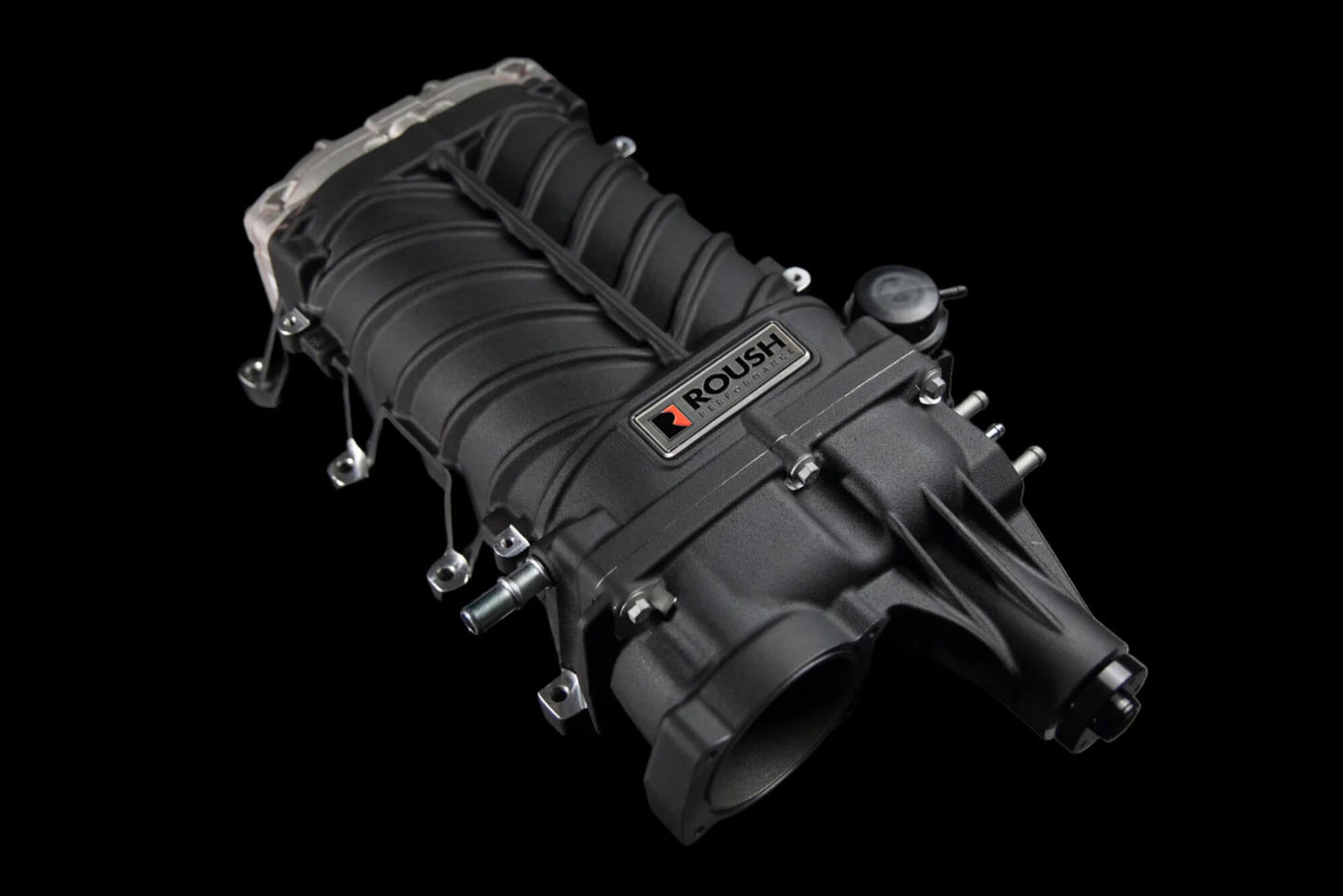 A black Roush Supercharger, likely designed for a Mustang GT, stands out against a sleek black background, hinting at its impressive 750 horsepower performance.