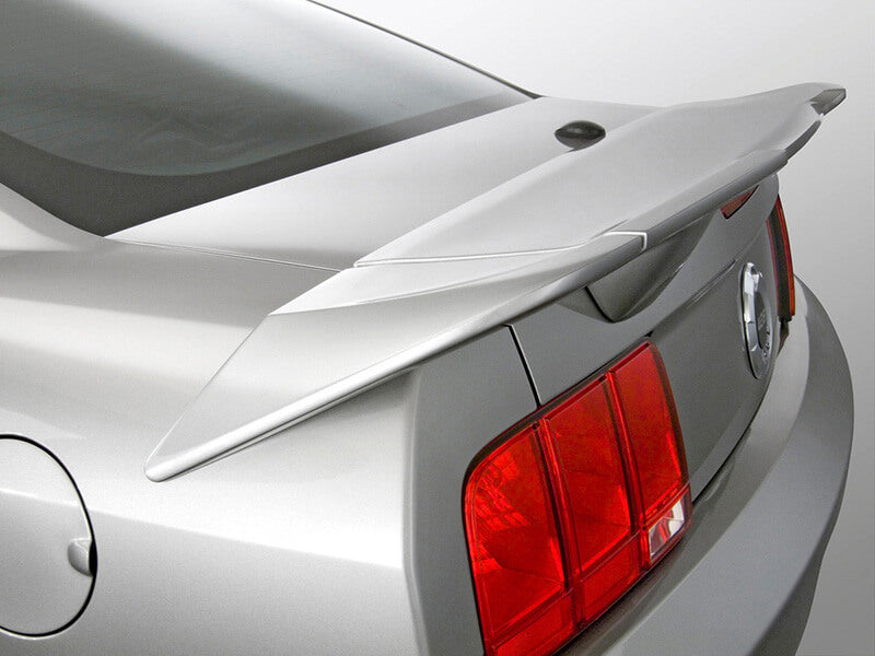 Rear view of a silver sports car with an ABS Mustang Rear Spoiler and striking red tail lights.