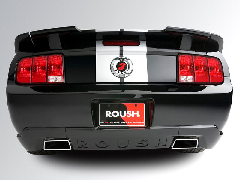 Rear view of a black Roush Ford Mustang featuring dual exhausts, red taillights, and a distinctive white racing stripe, complemented by an aerodynamic Mustang rear spoiler.