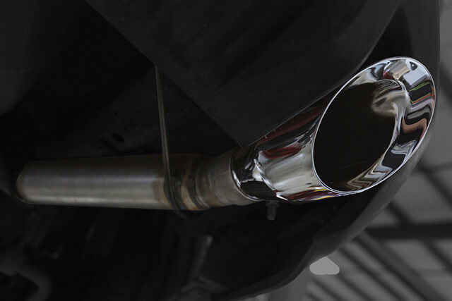A close-up of a gleaming chrome exhaust pipe, showcasing the sleek design of a Mustang GT Exhaust system.