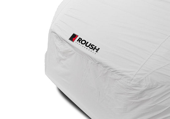 Close-up of a car enveloped in a sleek Roush Mustang car cover, crafted from water-resistant fabric and adorned with the iconic Roush logo and text.