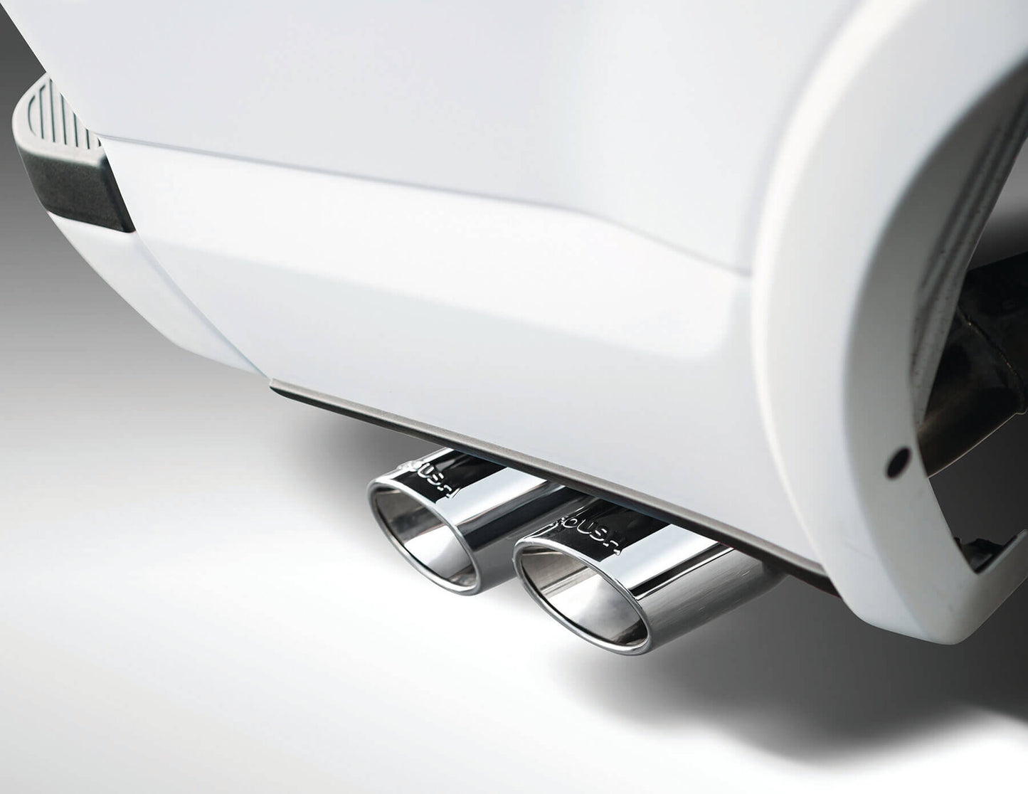 Close-up view of a vehicle's dual exhaust pipes with a chrome finish, showcasing the high-grade 304 stainless steel from the Roush F-150 Cat-Back Performance Exhaust Kit, extending stylishly from the rear of a 2021-2024 Ford F-150.