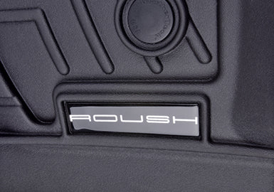 Close-up of a car interior featuring a "ROUSH" logo on a black panel with textured design elements, complemented by Roush WeatherTech Floor Mats for ultimate F-150 interior protection.