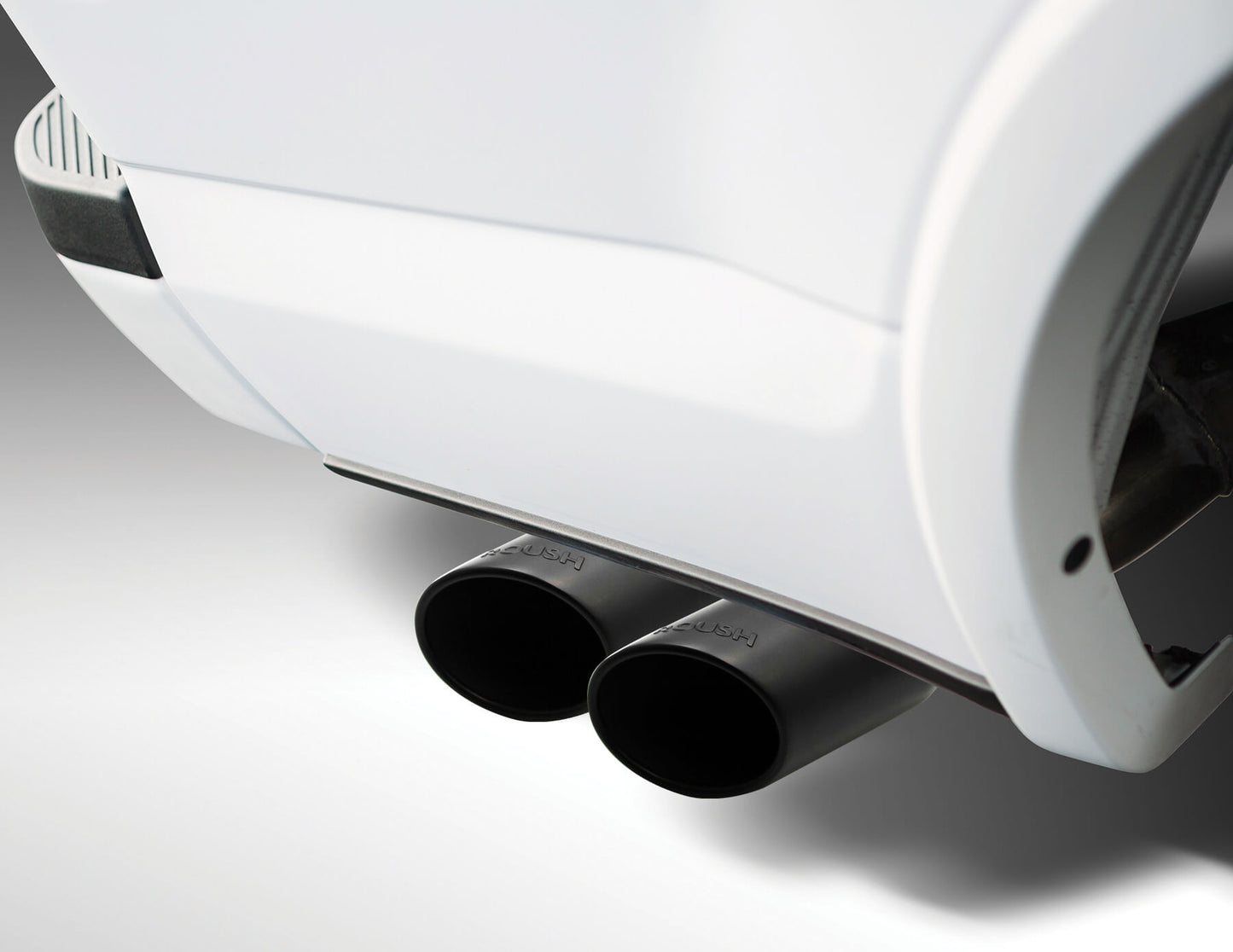 Close-up of a dual Roush Exhaust Kit on a white vehicle, showcasing the sleek design and performance.