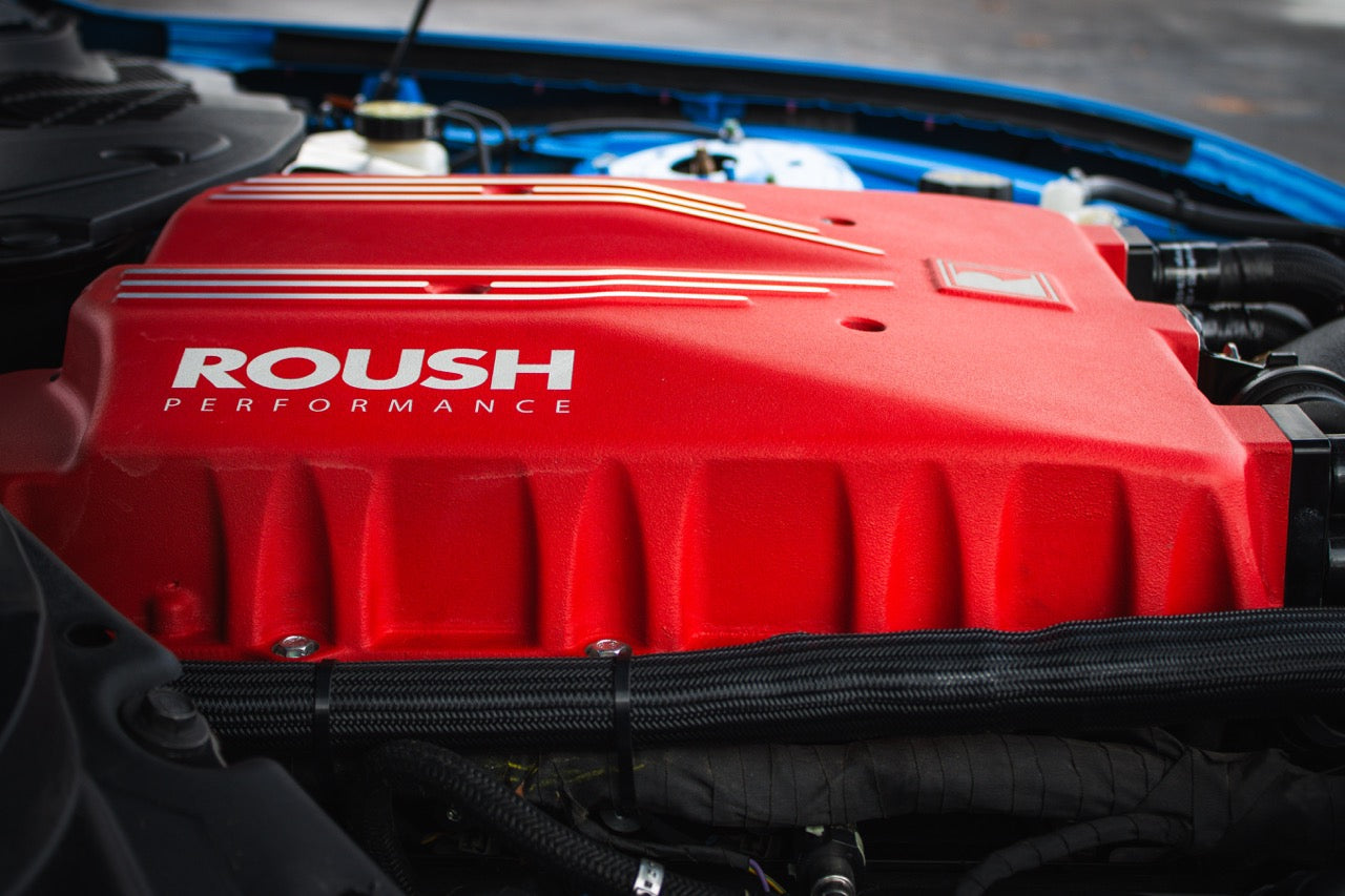 The red Roush Performance engine cover in the car houses a powerful supercharger kit, boosting it to an impressive 740 horsepower, making this Roush S650 Mustang a true beast on the road.
