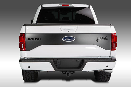 Rear view of a white Ford ROUSH F-150 truck with "ROUSH" branding and a signature decal on the tailgate, featuring the distinctive ROUSH Side-Exit Exhaust System.