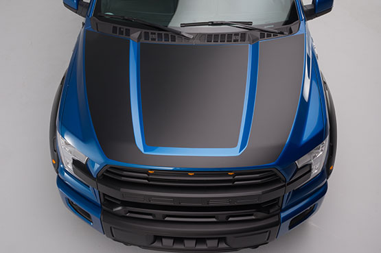 
                  
                    Overhead view of a blue and black ROUSH F-150 pickup truck with a prominent hood design, parked on a light-colored surface, showcasing its sleek ROUSH Side-Exit Exhaust System.
                  
                