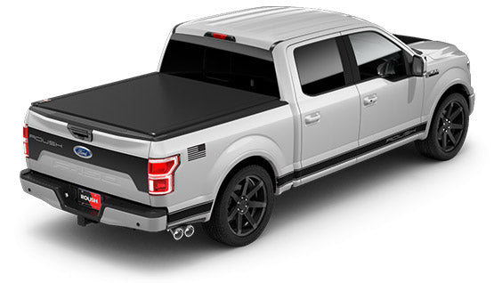 
                  
                    Silver pickup truck, ROUSH F-150 Sport, with a covered bed, black wheels, and dual exhaust pipes featuring the ROUSH Performance Exhaust System, viewed from the rear side angle.
                  
                