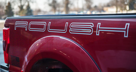 
                  
                    Red ROUSH Super Duty pickup truck with a "ROUSH" logo on the side, showcasing impressive towing capabilities.
                  
                