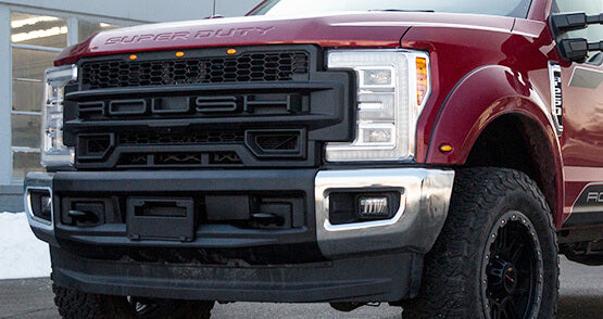 
                  
                    Front view of a red ROUSH Super Duty pickup truck parked, showcasing its large grille and chrome accents, highlighting its impressive towing capabilities.
                  
                