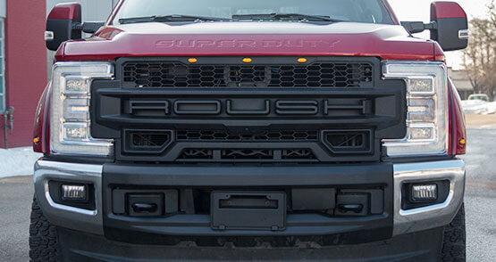 
                  
                    Front view of a red ROUSH Super Duty truck showcasing its prominent grille, large headlights, and impressive performance with exceptional towing capabilities.
                  
                