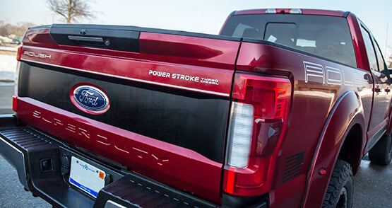 
                  
                    The red Ford ROUSH Super Duty truck, boasting a Power Stroke Turbo Diesel badge, showcases impressive performance and towing capabilities as it sits parked on the street.
                  
                