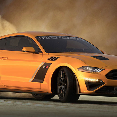 The ROUSH Stage 3 orange sports car, equipped with a supercharger and MagneRide suspension, effortlessly drifts on the sandy surface, creating an impressive dust cloud.