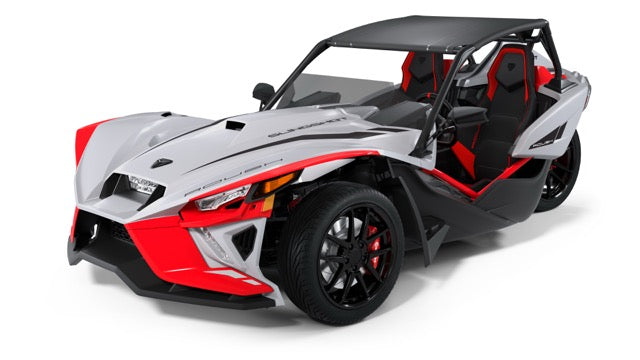 
                  
                    A three-wheeled, open-air Polaris Slingshot Roush Edition performance vehicle with a white, red, and black color scheme and two bucket seats exudes true racetrack attitude.
                  
                