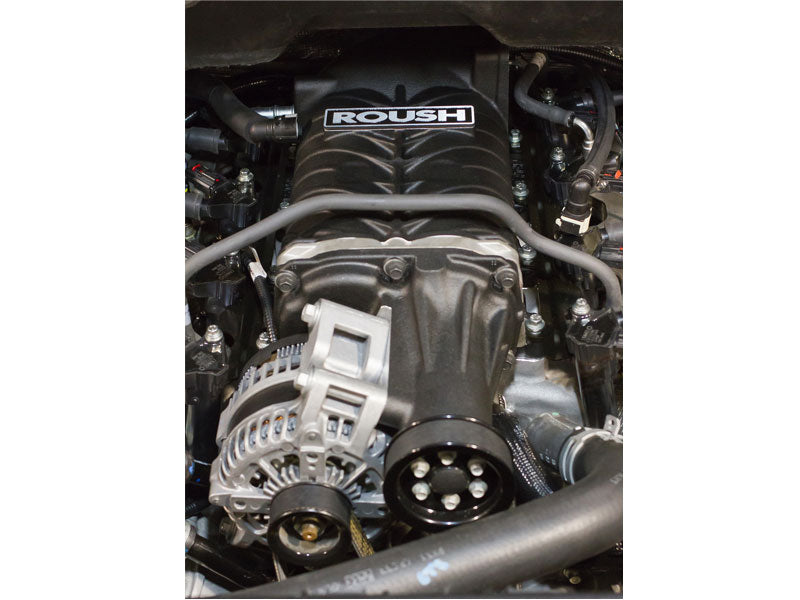 Close-up of a Roush R2300 branded car engine showcasing its impressive Ford F-150 Supercharger on the 6.2L engine, with various components like the alternator and belts.