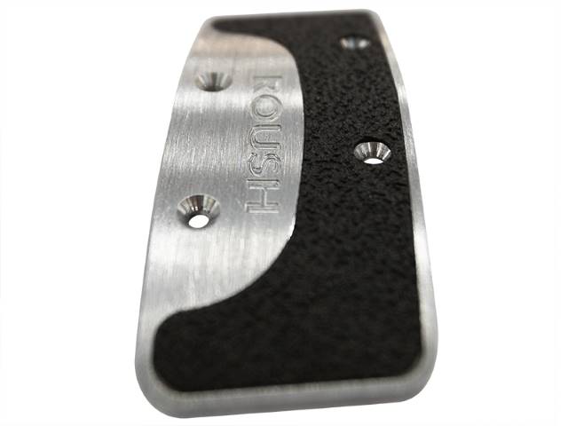 
                  
                    Close-up of a billet aluminum plate with the word "TOUGH" engraved, featuring three screw holes and a textured black surface. Perfect for enhancing your manual transmission Mustang with the durability of Roush Performance Pedal Kits.
                  
                
