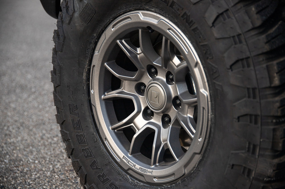 
                  
                    Close-up of a rugged tire with a silver and black rim, featuring a prominent Roush Performance Products, Inc. logo in the center.
                  
                