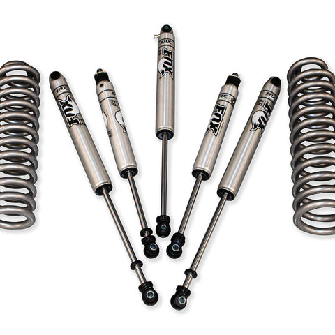 A set of car suspension parts arranged on a white background, including two coiled springs and four Fox shocks marked "FORD Super Duty.