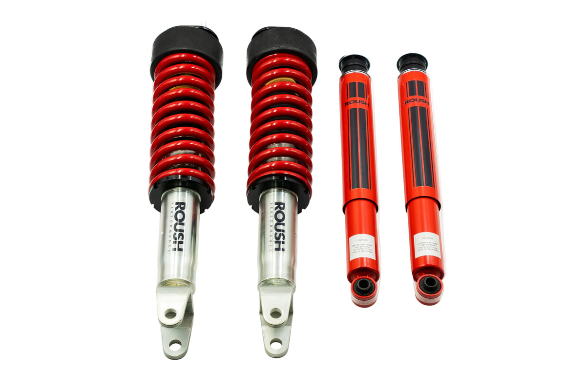 
                  
                    Two Roush coilover suspension struts and two matching red shock absorbers, designed as part of a premium performance suspension system for the Ram 1500, are arranged side by side on a white background.
                  
                