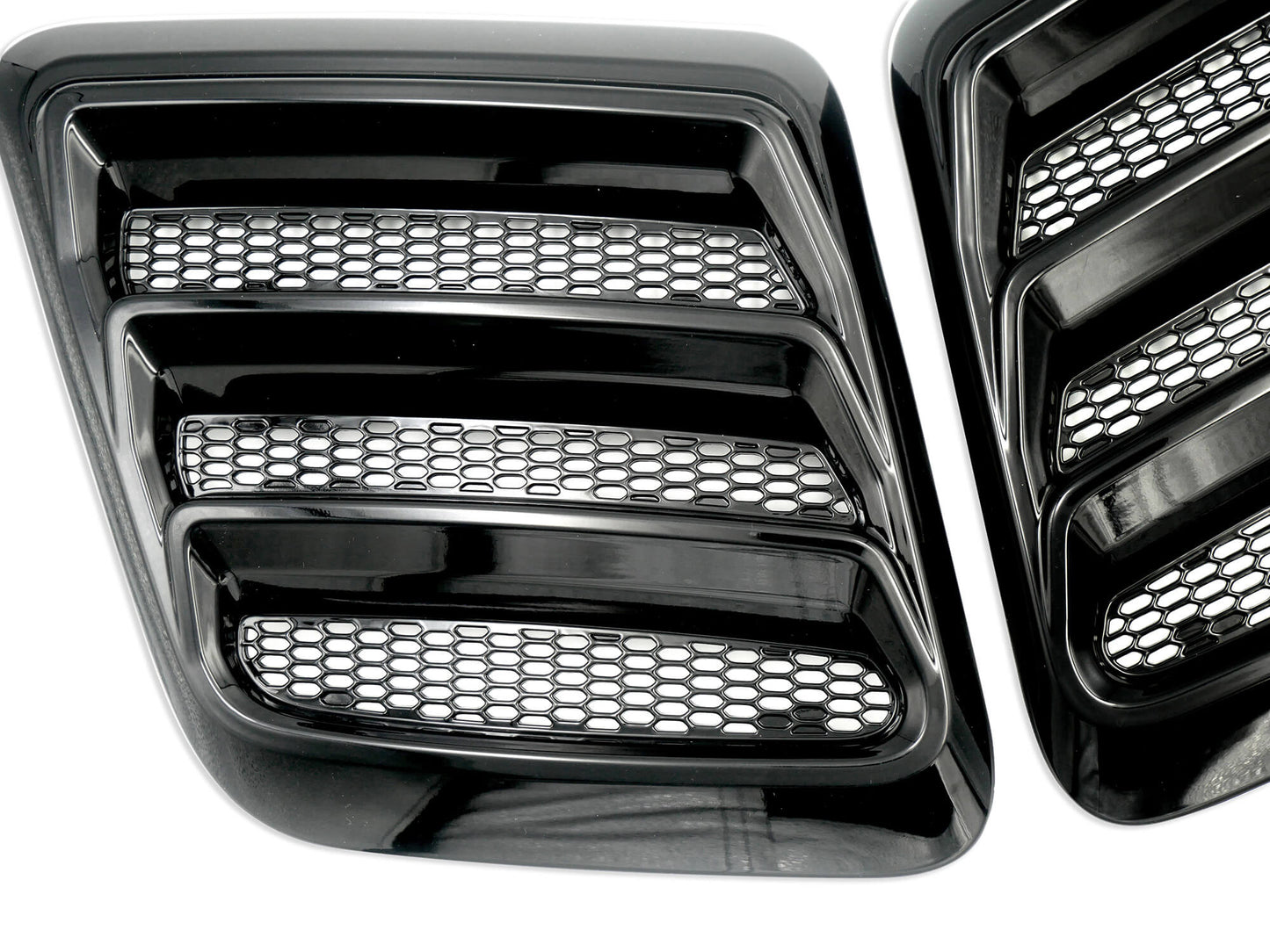 
                  
                    Close-up of two gloss black Roush Performance Mustang Hood Heat Extractors with a honeycomb mesh design.
                  
                