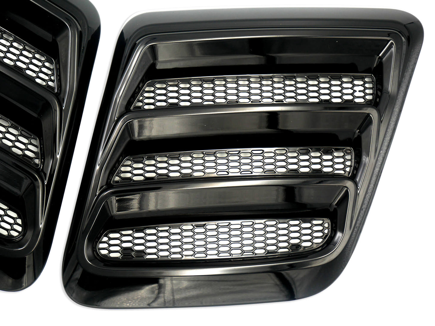 
                  
                    Close-up of 2018-2023 Mustang hood heat extractors featuring a gloss black finish and a striking honeycomb mesh pattern.
                  
                