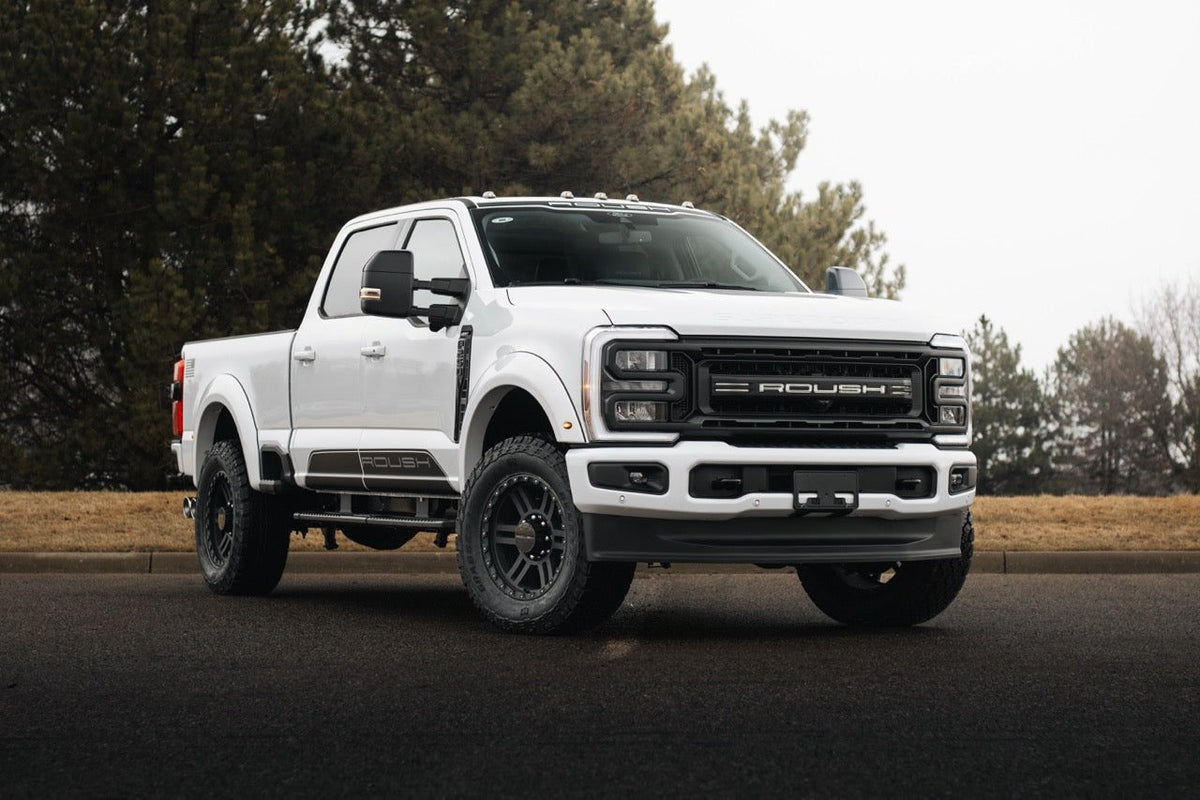 
                  
                    White 2025 Roush Super Duty truck parked on an asphalt road.
                  
                