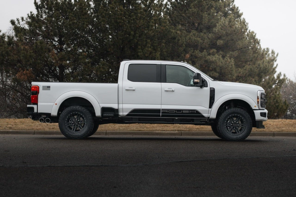 
                  
                    White 2025 Roush Super Duty crew cab pickup truck parked on the side of a road.
                  
                
