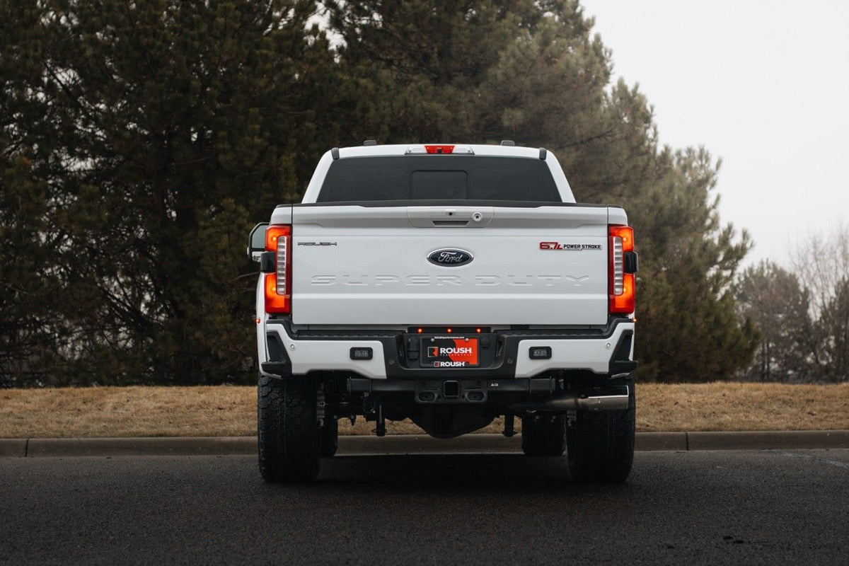 
                  
                    Rear view of a white 2025 Roush Super Duty pickup truck parked on asphalt.
                  
                