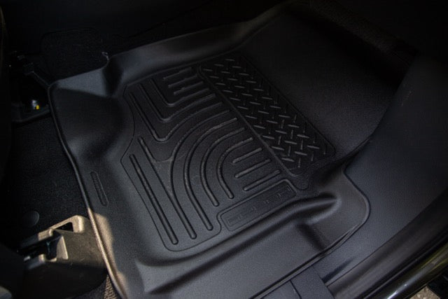 
                  
                    Black rubber car floor mat with raised edges and textured surface, installed on the front passenger side of a Ford F-250, complements the rugged interior of the 2023 Roush Super Duty with performance suspension.
                  
                