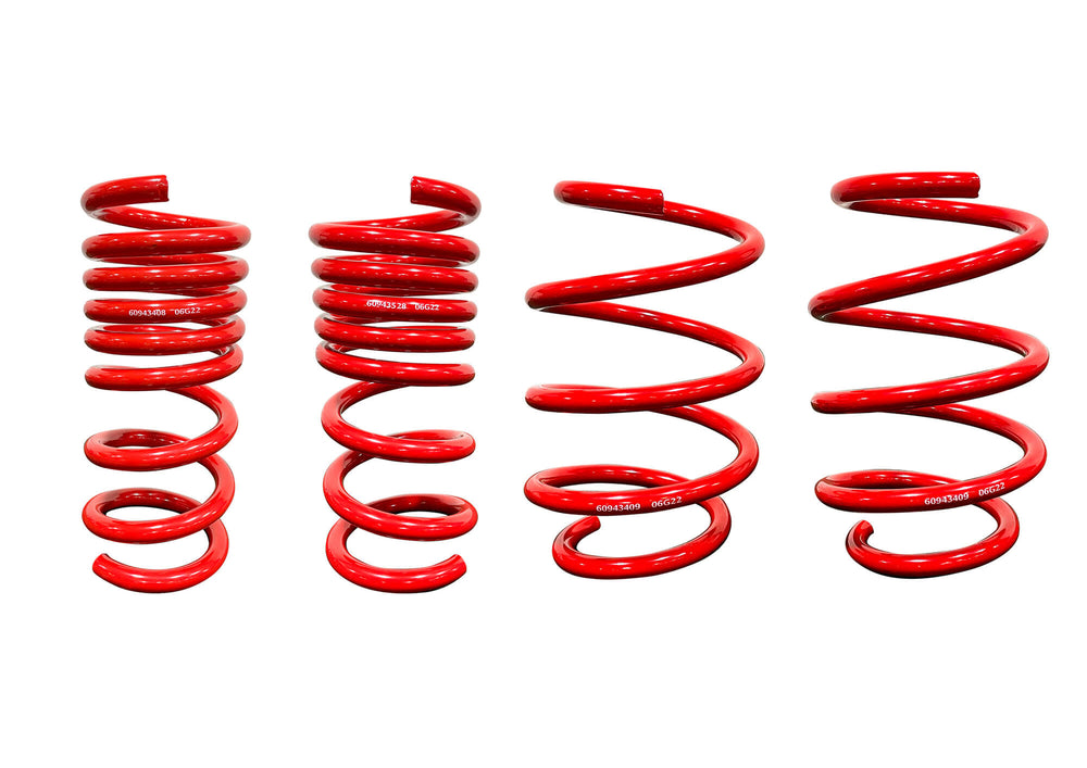 Four red, coiled lowering springs of varying heights and thicknesses are aligned in a row against a white background, reminiscent of the robust Mustang Roush MagneRide Suspension Kit.