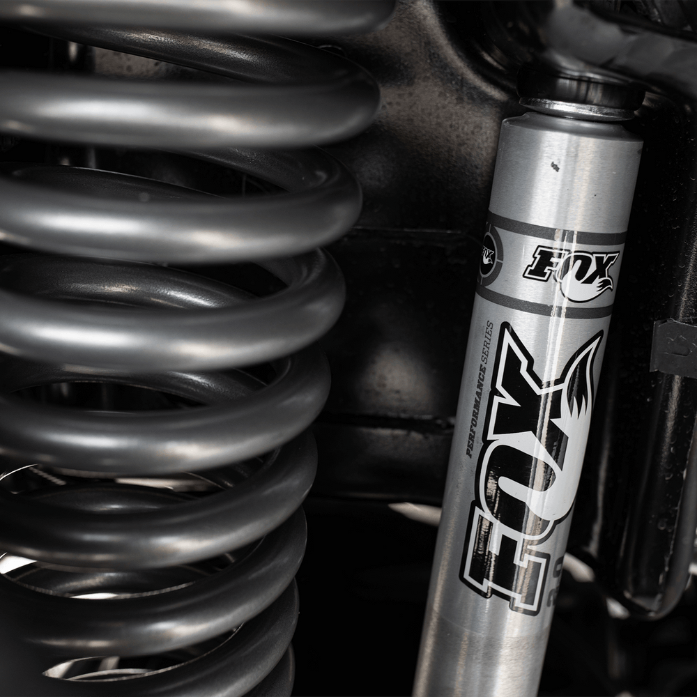 
                  
                    Close-up view of a FOX suspension shock absorber and coil spring in a 2022 ROUSH F-150's advanced suspension system.
                  
                