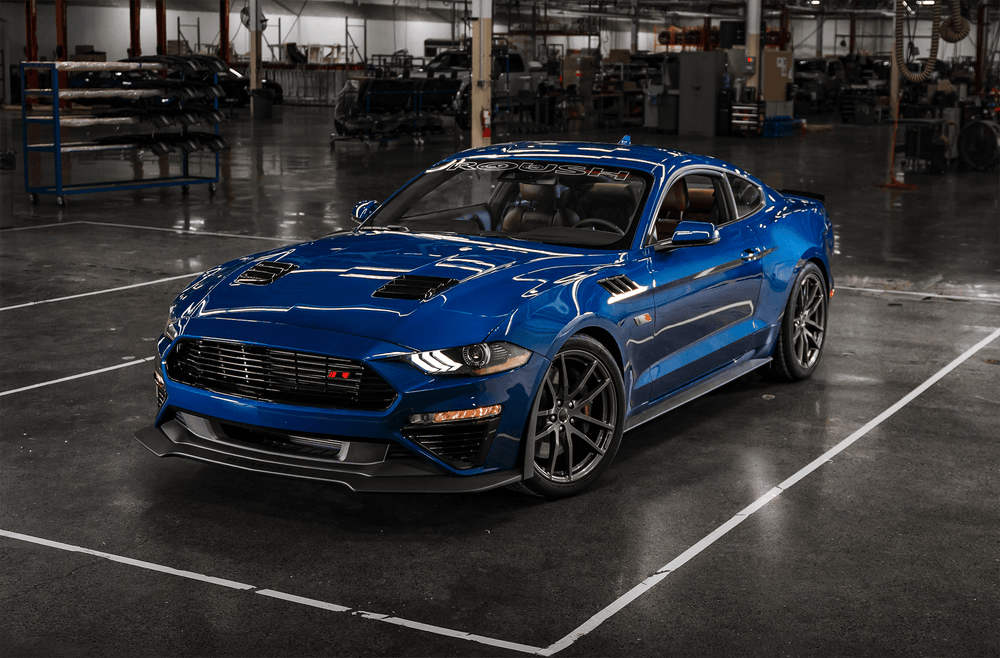 A shiny blue Roush Mustang is parked inside an industrial-style garage, exuding unparalleled performance.